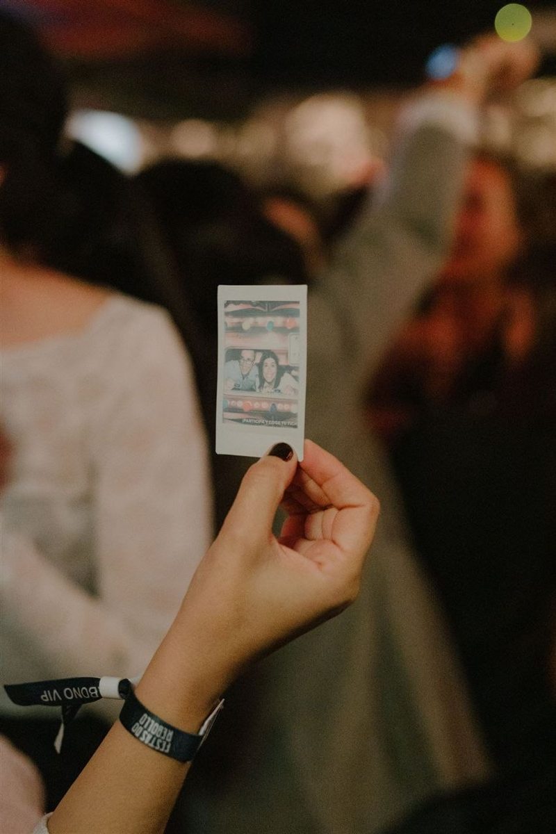 Una invitada enseña la polaroid del photocall en una preboda