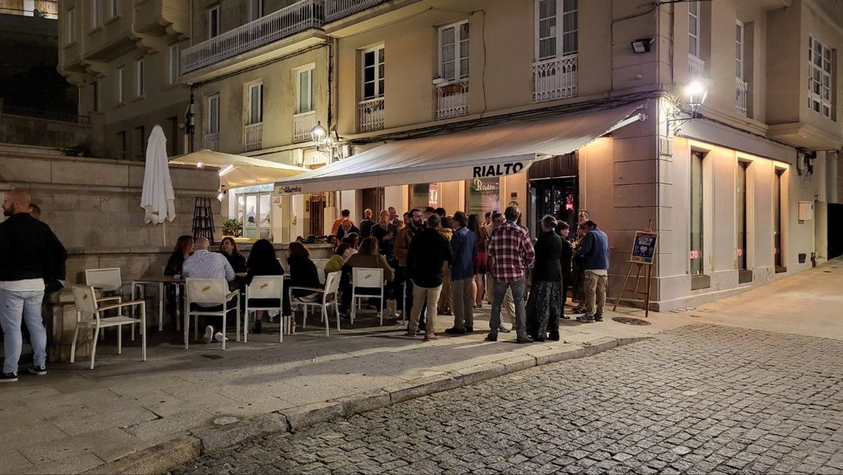 La terraza de Rialto de noche en la Praza de María Pita, con invitados en la puerta