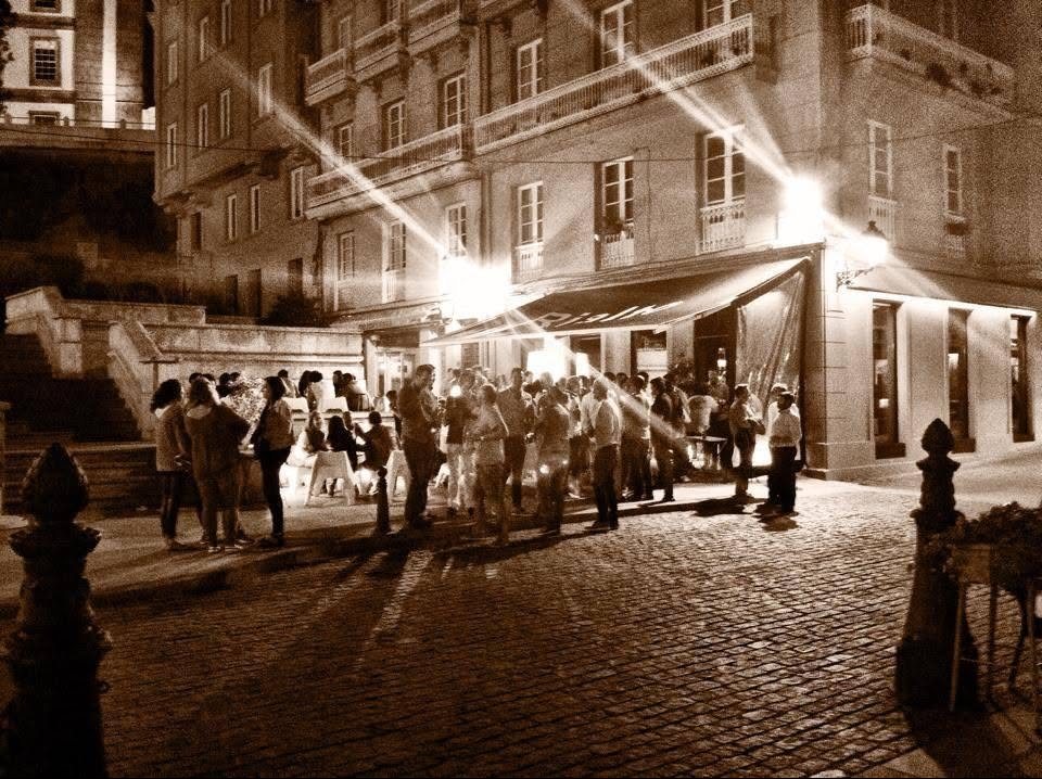 La terraza de Rialto llena de gente de noche, vista desde la plaza