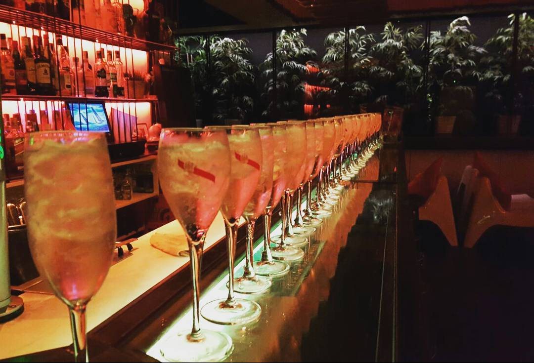 Una fila de copas preparadas para el brindis a lo largo de la barra